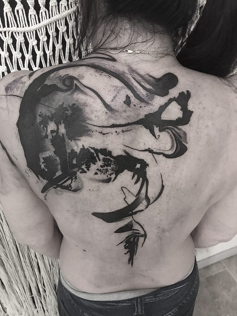 Big blackwork tatto on the back of the client.
